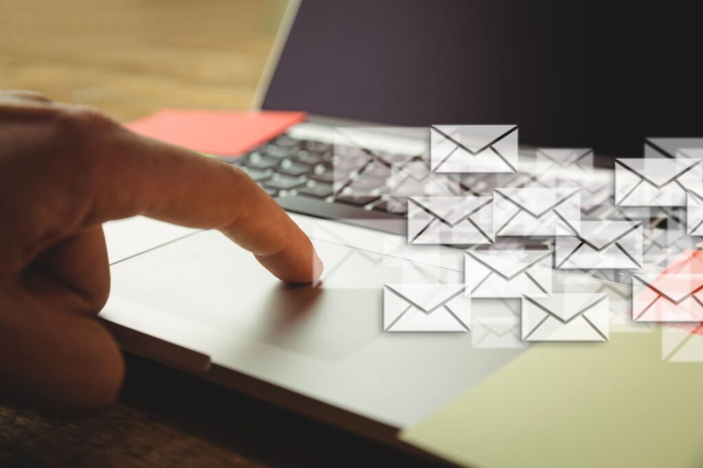 Close up of hand touching laptop with many envelopes